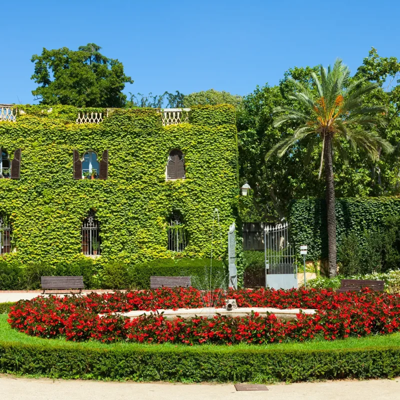 Giardino curato con siepi e facciata di villa
